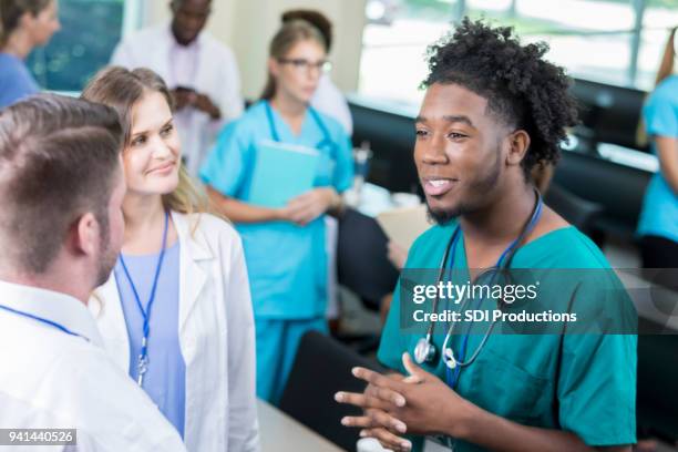 young male medical student asks professor a question - community college stock pictures, royalty-free photos & images