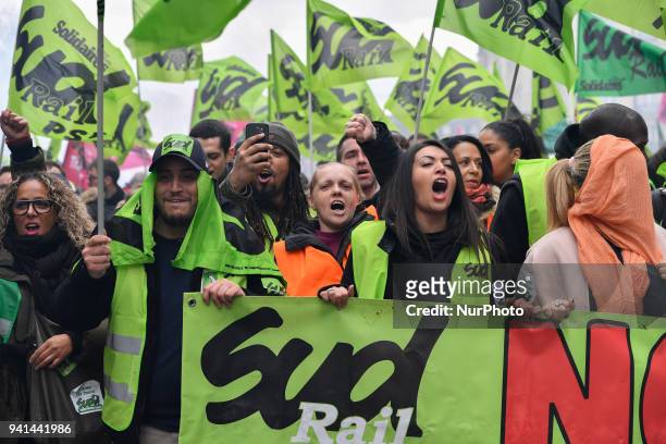 Protesters walk behind a banner during a protest march by railway workers and other labor union members in Paris, France, on Tuesday April 3, 2018....
