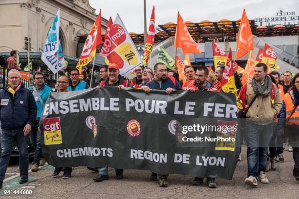 Protesters of SNCF employees walk behind a banner during a protest march by railway workers and other labor union members in Lyon, France, on Tuesday...