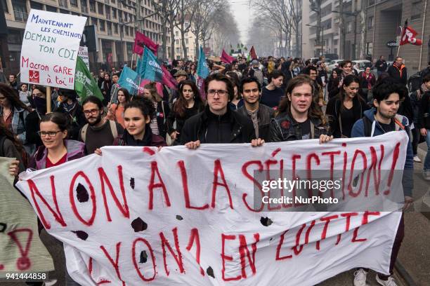 Protesters of SNCF employees walk behind a banner during a protest march by railway workers and other labor union members in Lyon, France, on Tuesday...