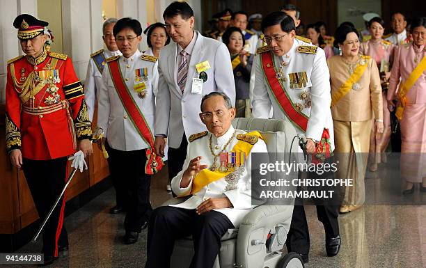 Thai King Bhumibol Adulyadej waves to a crowd of well-wishers as he leaves the Siriraj Hospital on a wheelchair pushed by doctors, in Bangkok on...