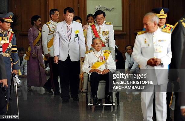 Thai King Bhumibol Adulyadej leaves the Siriraj Hospital on a wheelchair pushed by doctors, in Bangkok on December 5, 2009. Thailand's revered king...
