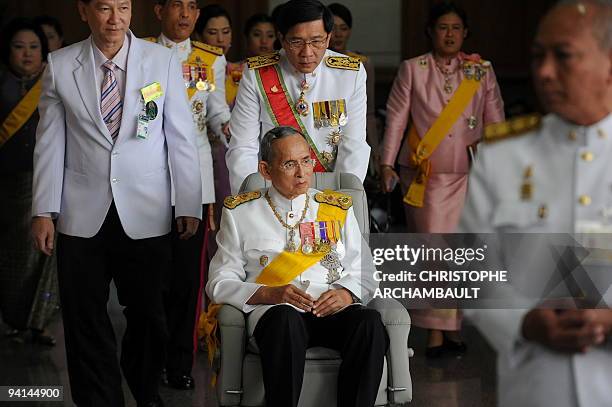 Thai King Bhumibol Adulyadej leaves the Siriraj Hospital on a wheelchair pushed by doctors, in Bangkok on December 5, 2009. Thailand's revered king...