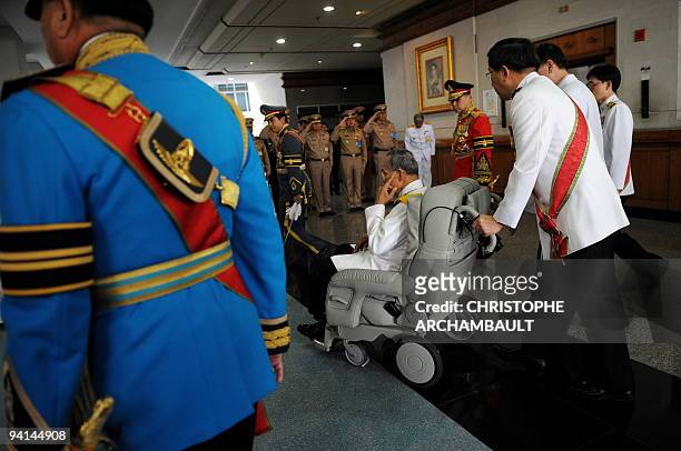 Thai King Bhumibol Adulyadej leaves the Siriraj Hospital on a wheelchair pushed by doctors, in Bangkok on December 5, 2009. Thailand's revered king...