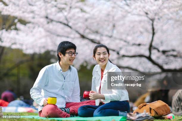 japanisches paar picknick im frühjahr - hanami stock-fotos und bilder