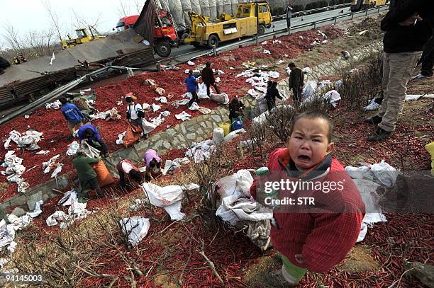 Child cries as Chinese villagers gather to salvage what is left of the cargo on a truck carrying gunpowder to a fireworks factory, which exploded in...