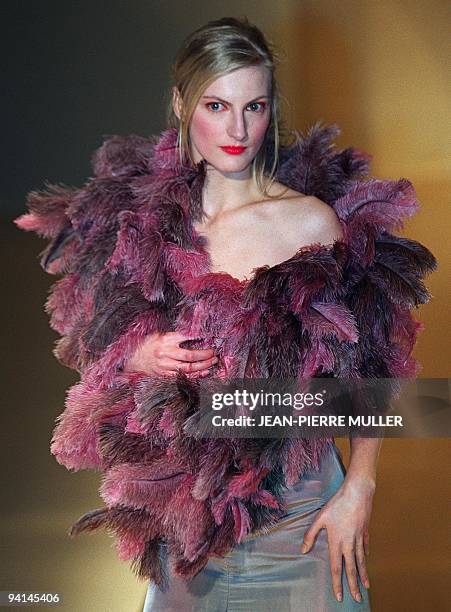 Model presents a shoulderless steel-coloured dress with purple feather boa for Stella Cadente during the Autumn-Winter 2000/2001 ready-to-wear...