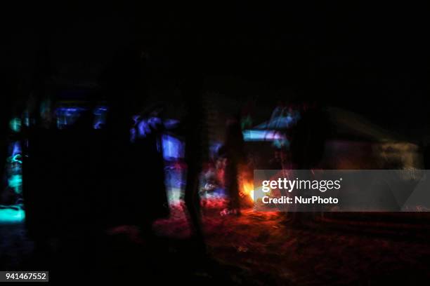 Palestinians are burning firewood to heat out their tents at sunset. On April 2, 2018 along the border with Israel east of Gaza City during a tent...