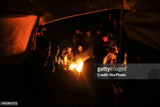 Palestinians are burning firewood to heat out their tents at sunset. On April 2, 2018 along the border with Israel east of Gaza City during a tent...