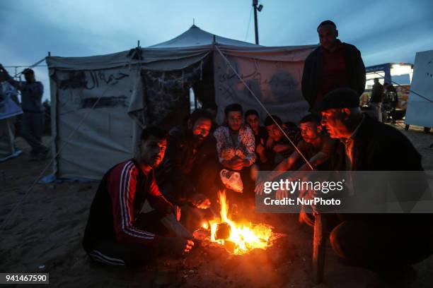 Palestinians are burning firewood to heat out their tents at sunset. On April 2, 2018 along the border with Israel east of Gaza City during a tent...