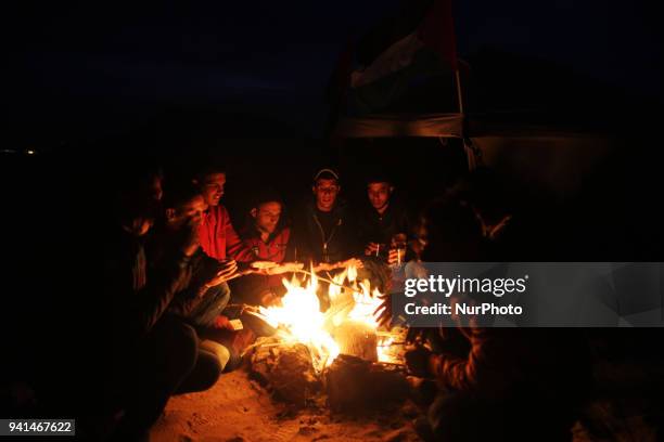 Palestinians are burning firewood to heat out their tents at sunset. On April 2, 2018 along the border with Israel east of Gaza City during a tent...