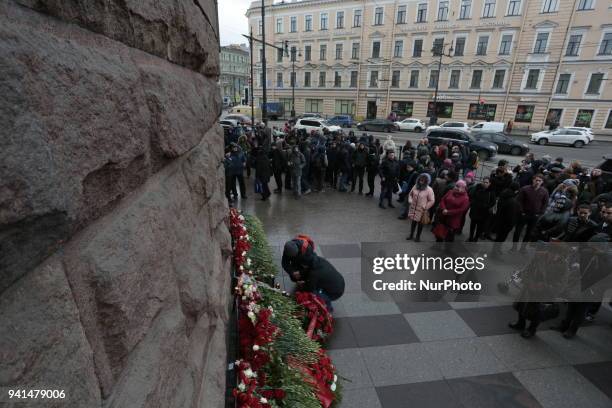 People put flowers during the rally in memory of the victims of the explosion in the St. Petersburg metro on the first anniversary of the attack. St....