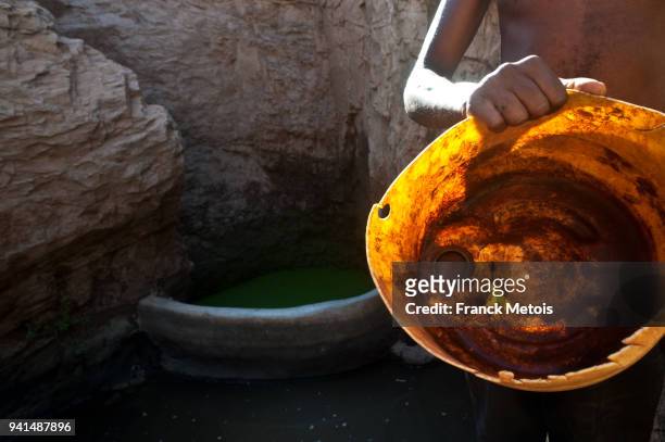 man fetching water in a "singing well" ( ethiopia) - borana stock pictures, royalty-free photos & images
