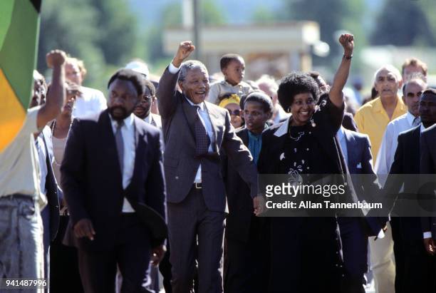Outside Victor Verster prison, married South African anti-apartheid activists Nelson Mandela and Winnie Mandela raise their fists as they celebrate...