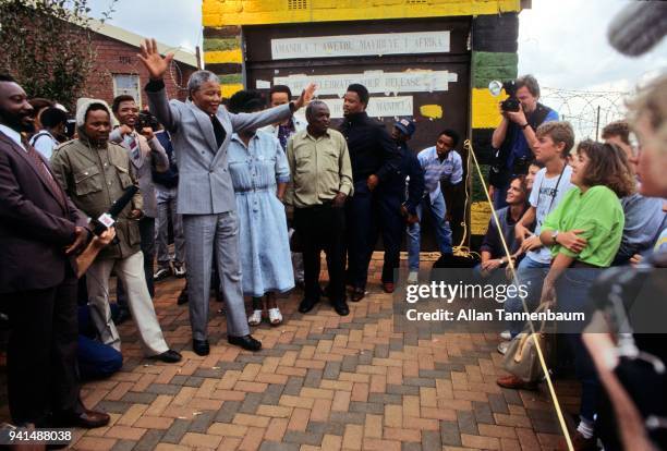 South African anti-apartheid activist Nelson Mandela raises his arms as he speaks with members of the press and students outside his home, Soweto,...