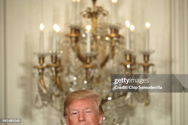 President Donald Trump winks during a joint news conference with Estonian President Kersti Kaljulaid, Latvian President Raimonds Vejonis and...