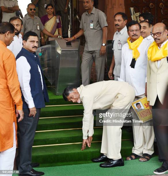 Andhra Pradesh Chief Minister N Chandrababu Naidu touches the stair before entering the Parliament as he arrives to attend his party's protest for...