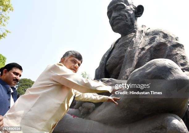 Andhra Pradesh Chief Minister N Chandrababu Naidu paying floral tributes on the statue of Mahatma Gandhi as he arrives to attend his party's protest...