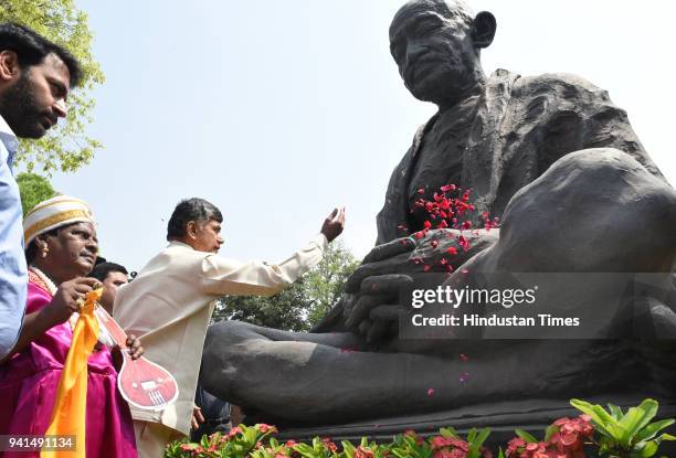 Andhra Pradesh Chief Minister N Chandrababu Naidu pays floral tribute to the statue of Mahatma Gandhi as he arrives to attend his party's protest for...