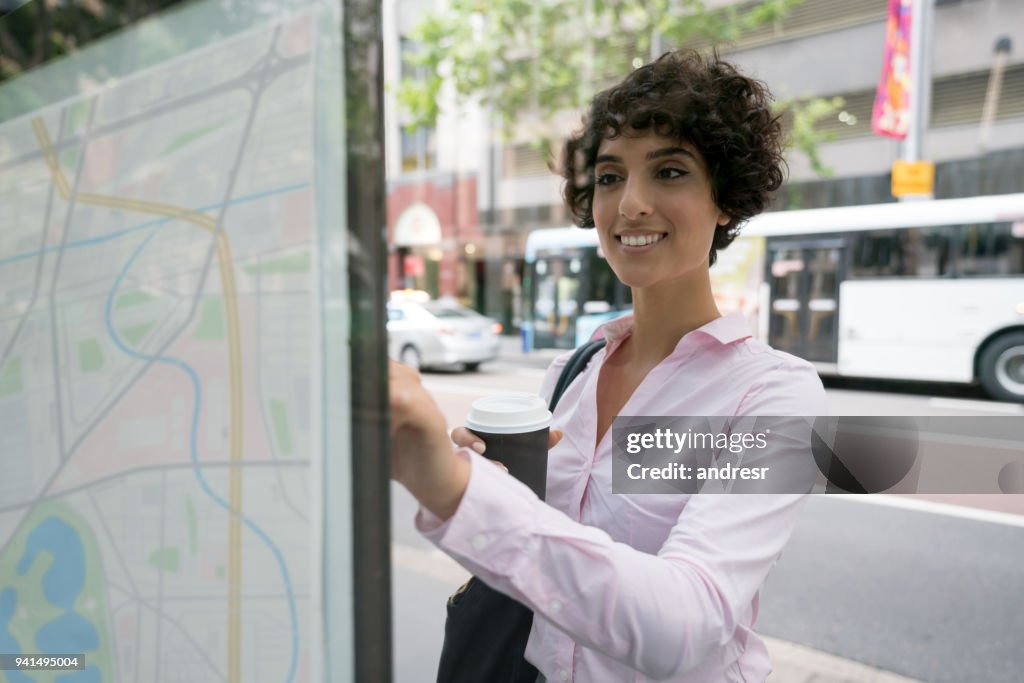 Business woman looking at a map on the street