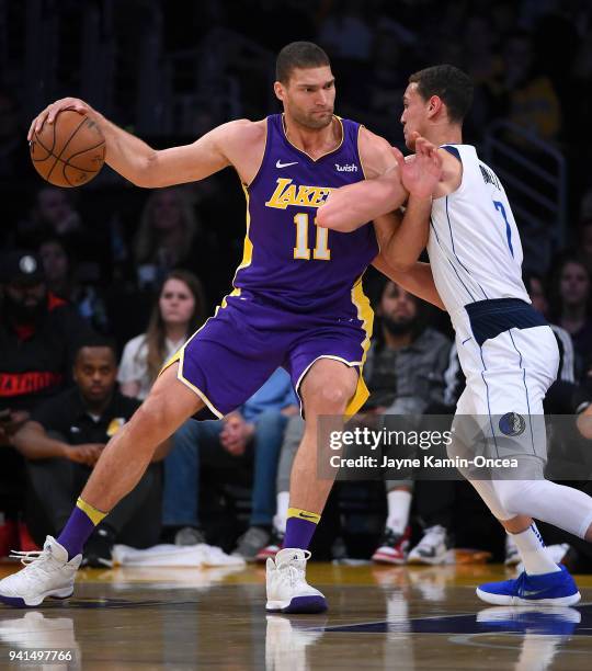 Dwight Powell of the Dallas Mavericks guards Brook Lopez of the Los Angeles Lakers in the game at Staples Center on March 28, 2018 in Los Angeles,...