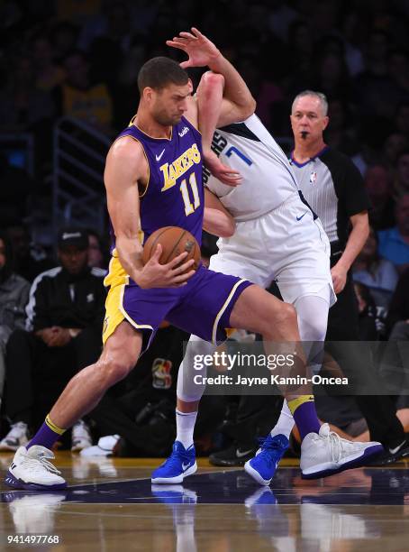 Dwight Powell of the Dallas Mavericks guards Brook Lopez of the Los Angeles Lakers in the game at Staples Center on March 28, 2018 in Los Angeles,...