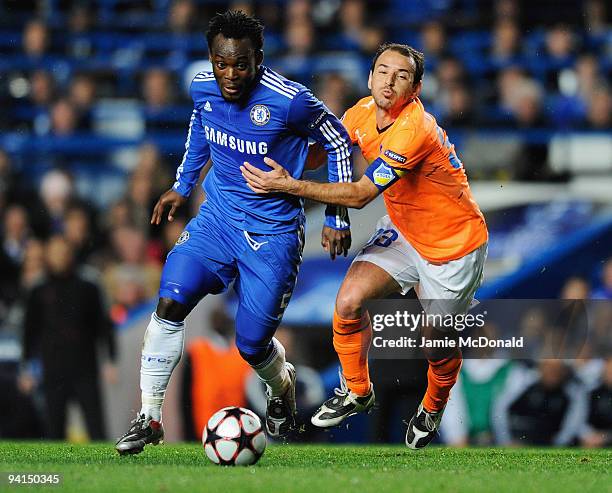 Michael Essien of Chelsea holds off Hrysis Mihail of APOEL Nicosia to score their first goal during the UEFA Champions League Group D match between...