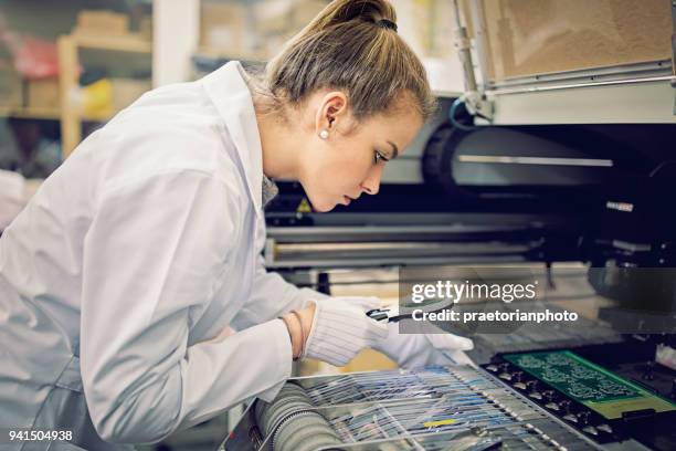 woman is working with resistors pick and place machine in circuit board factory - semiconductor imagens e fotografias de stock