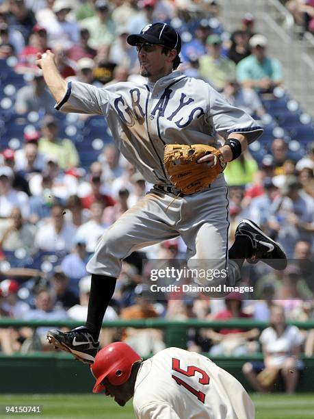 Shortstop Chris Gomez of the Pittsburgh Pirates leaps over the sliding Cristian Guzman of the Washington Nationals trying to complete a double play...