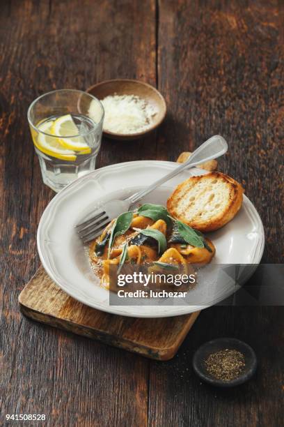 tortelloni mit fleisch, salbei und demi-glace sauce - tortelloni stock-fotos und bilder