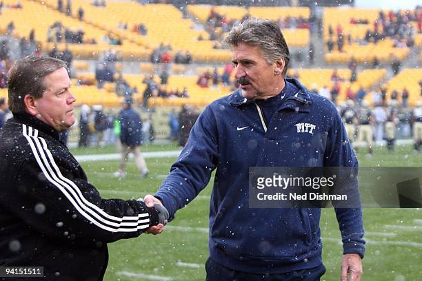 Head Coach Dave Wannstedt of the University of Pittsburgh Panthers meets with Head Coach Brian Kelly of the University of Cincinnati Bearcats at...
