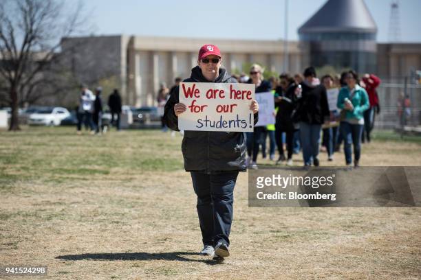 Teacher holds a sign during a strike outside the Oklahoma State Capitol building in Oklahoma City, Oklahoma, U.S., on Tuesday, April 3, 2018....