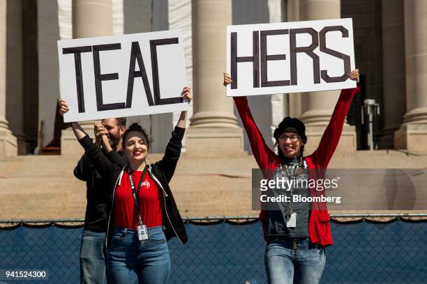 Demonstrators hold signs that read "Teachers" during a strike outside the Oklahoma State Capitol building in Oklahoma City, Oklahoma, U.S., on...