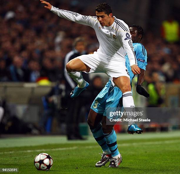 Cristiano Ronaldo of Real Madrid leaps above the challenge of Taye Taiwo during the Marseille v Real Madrid UEFA Champions League Group C match at...