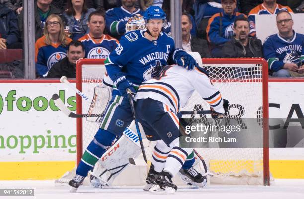Henrik Sedin of the Vancouver Canucks battles with Kris Russell of the Edmonton Oilers in front of the net in NHL action on March 2018 at Rogers...