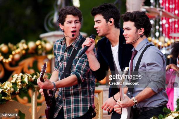 In this handout photo provided by Disney, The Jonas Brothers Nick Jonas, Joe Jonas and Kevin Jonas perform in front of Cinderella Castle at the Magic...