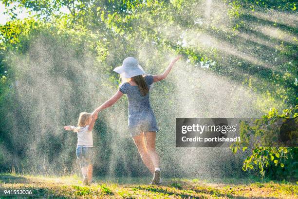 mutter und kind spaß im regen - girls in wet dresses stock-fotos und bilder