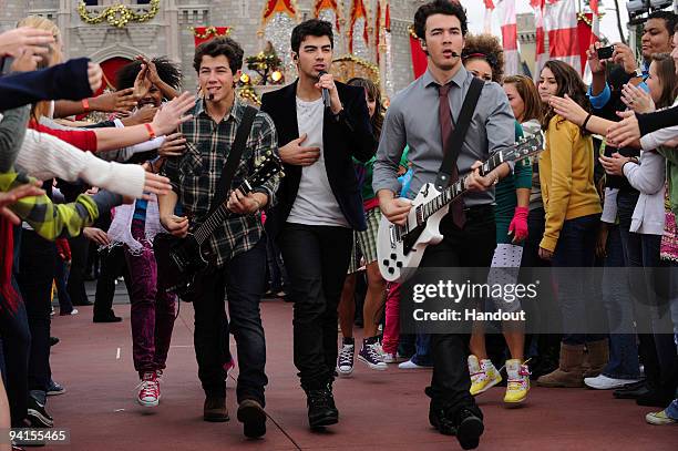 In this handout photo provided by Disney, The Jonas Brothers Nick Jonas, Joe Jonas and Kevin Jonas perform in front of Cinderella Castle at the Magic...