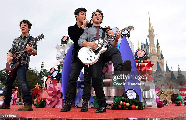 In this handout photo provided by Disney, The Jonas Brothers Nick Jonas, Joe Jonas and Kevin Jonas perform in front of Cinderella Castle at the Magic...