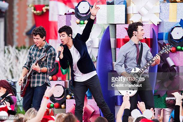 In this handout photo provided by Disney, The Jonas Brothers Nick Jonas, Joe Jonas and Kevin Jonas perform in front of Cinderella Castle at the Magic...