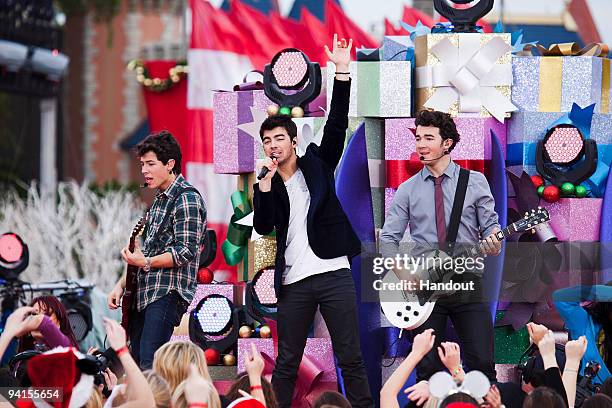 In this handout photo provided by Disney, The Jonas Brothers Nick Jonas, Joe Jonas and Kevin Jonas perform in front of Cinderella Castle at the Magic...