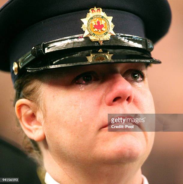 Meachel Chad, a corrections officer with Correctional Services Canada, sheds a tear as she watches a video during a memorial service for the four...