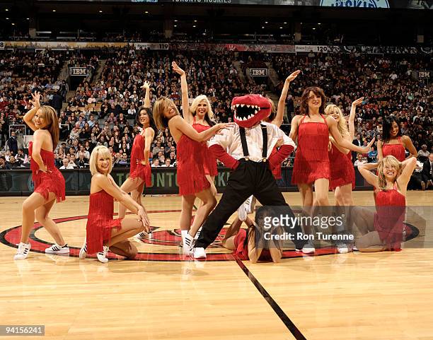 The Raptor poses with the Raptors Dance Pack after a routine to honour the Toronto Huskies during a game featuring the Toronto Raptors and the...