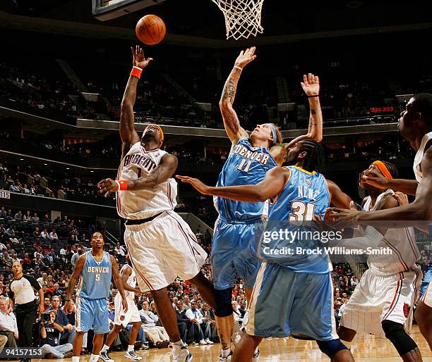 Stephen Jackson of the Charlotte Bobcats goes up for the layup against Chris Andersen of the Denver Nuggets on December 8, 2009 at the Time Warner...