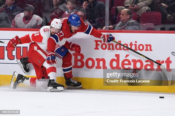 Alex Galchenyuk of the Montreal Canadiens loses control of the puck against Xavier Ouellet of the Detroit Red Wings in the NHL game at the Bell...
