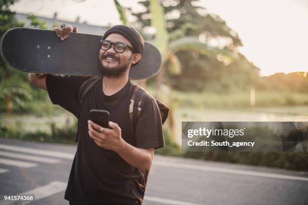 skater man with mobile phone - indonesia street stock pictures, royalty-free photos & images
