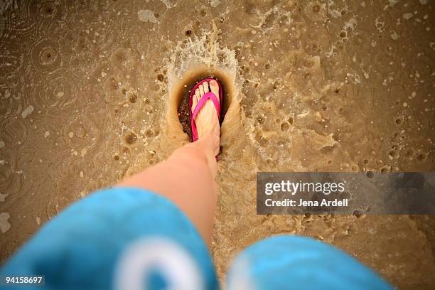 girl walking thru large puddle in the summertime - unterer teil stock-fotos und bilder