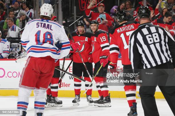 Taylor Hall of the New Jersey Devils is congratulated on his first period goal by Travis Zajac and Patrick Maroon as Marc Staal of the New York...