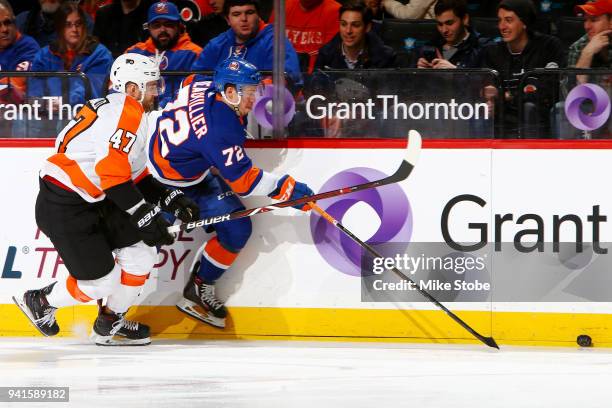 Anthony Beauvillier of the New York Islanders and Andrew MacDonald of the Philadelphia Flyers race for a loose puck during the first period at...