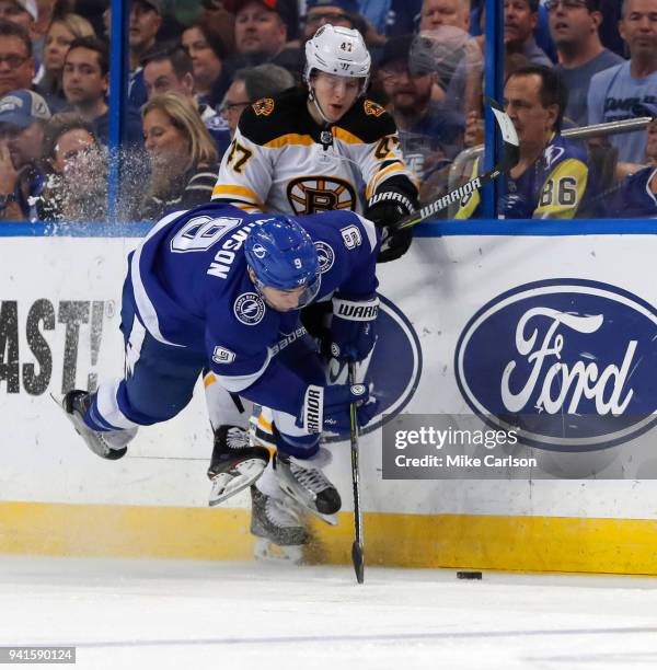 Torey Krug of the Boston Bruins hits Tyler Johnson of the Tampa Bay Lightning during the first period of the game at the Amalie Arena on April 3,...